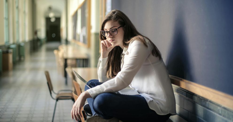 Woman in glasses on a desk, contemplating separation because of domestic violence