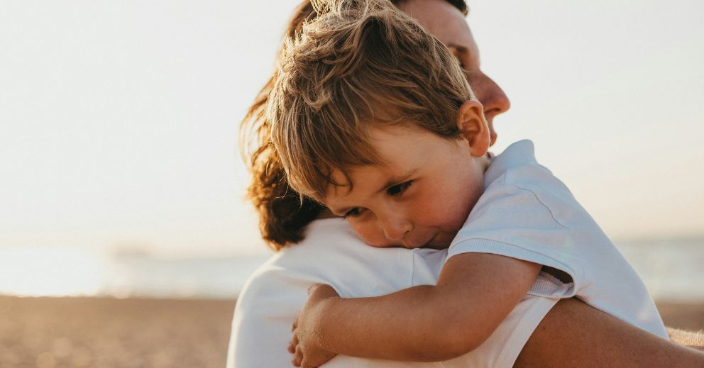 A young child hugs an adult on a beach—family law attorney cost Australia concerns melt away.