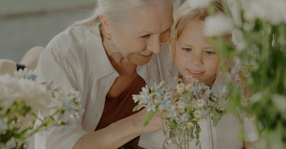 Older woman and young girl arranging flowers, symbolizing grandparents' rights in family law.