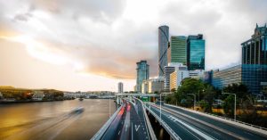 A city skyline at sunset, with highways and views towards the cost of a divorce lawyer in Brisbane.