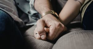 Two people sitting closely, holding hands—new partners can affect parenting arrangements.