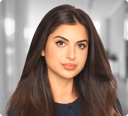 Woman with long brown hair and a blue top poses in a well-lit office for family lawyers.